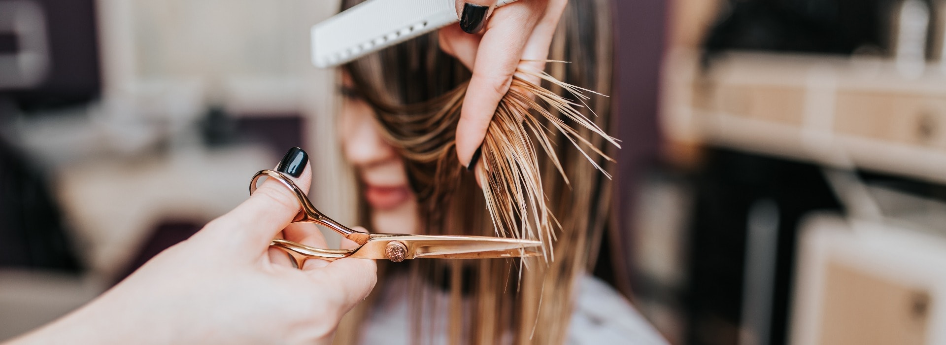 Beautiful young woman getting her haircut by a hairstylist at a beauty salon.