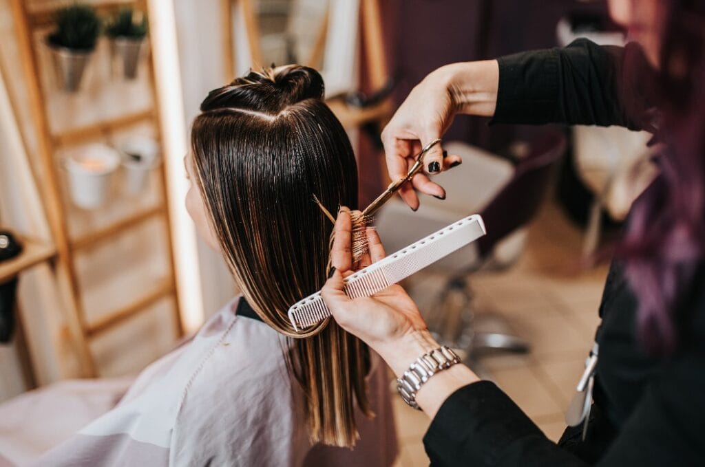 Beautiful young woman preparing for haircut at a beauty salon.